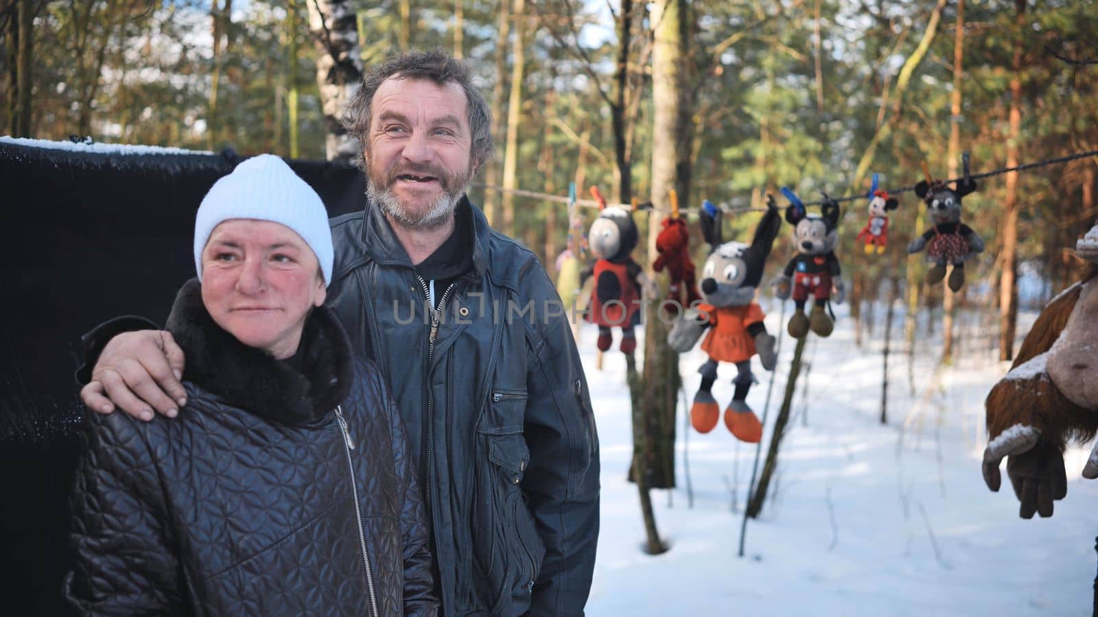 A homeless man and woman giving an interview in the winter in the woods