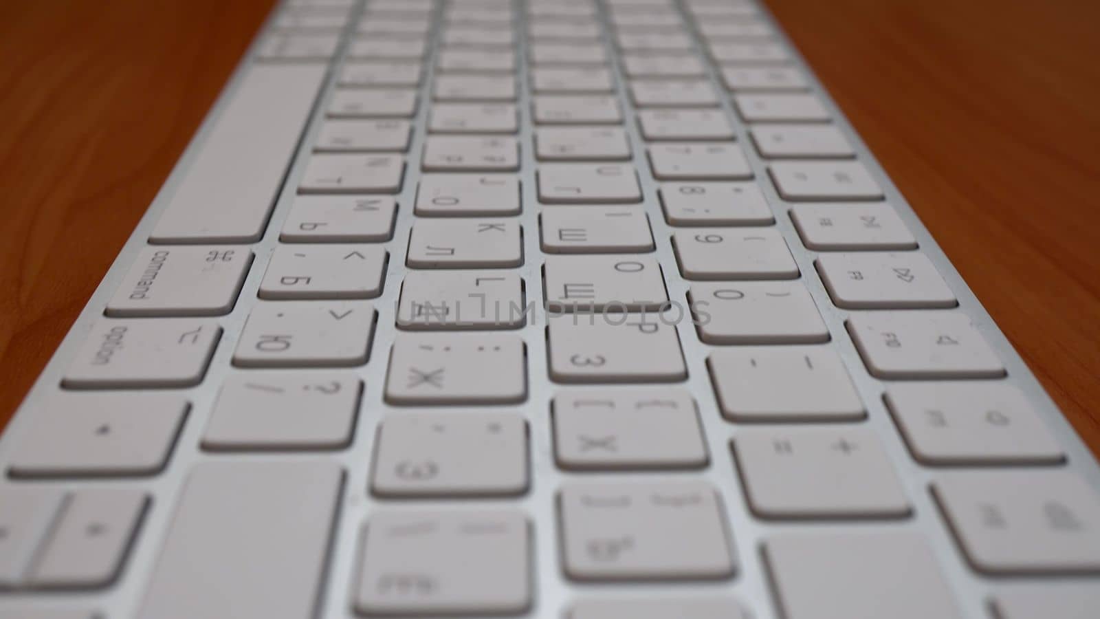 White wireless keyboard on the table close-up. The camera moves away from the keyboard. Macro. 4k