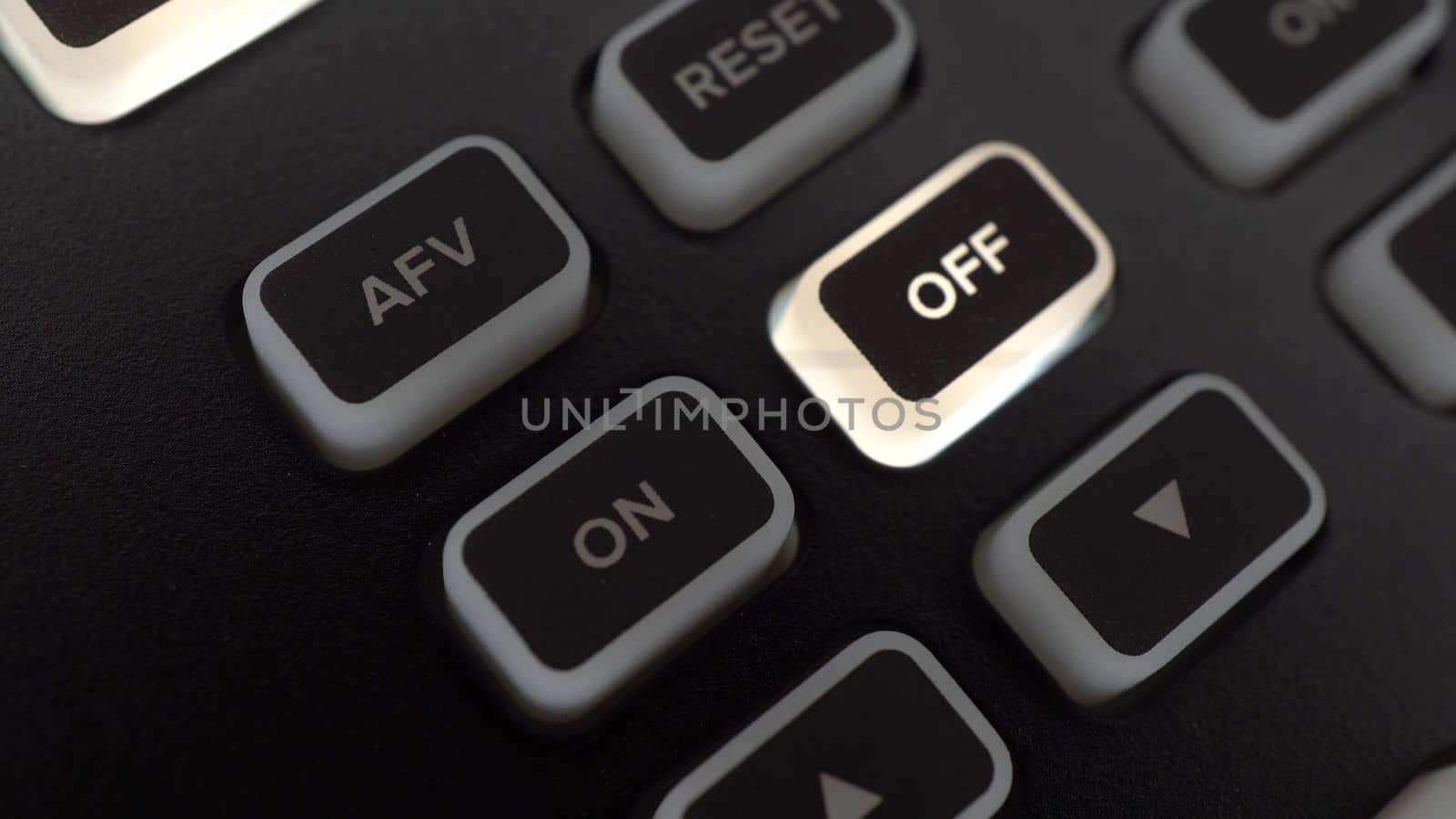 A man presses the off button on the video remote control. Video mixer controlling audio on cameras. Macro. 4k