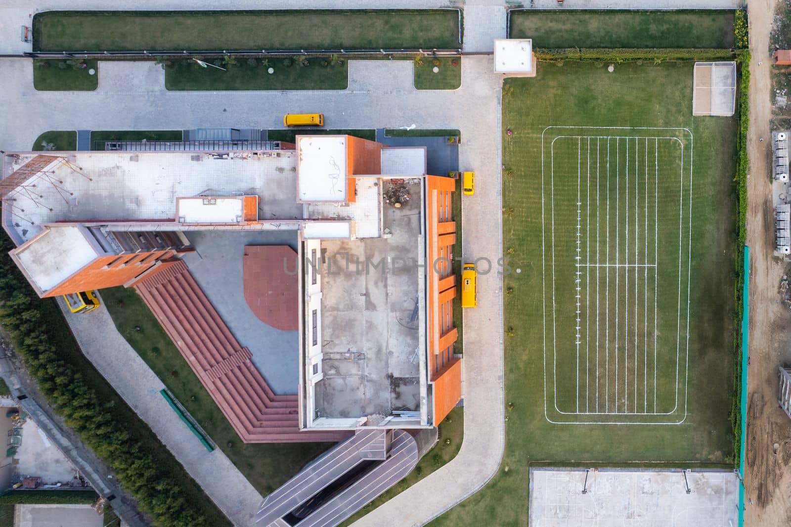 aerial drone shot looking straight down on school and it's playing feild with lines marked for sports in gurgaon Delhi India by Shalinimathur