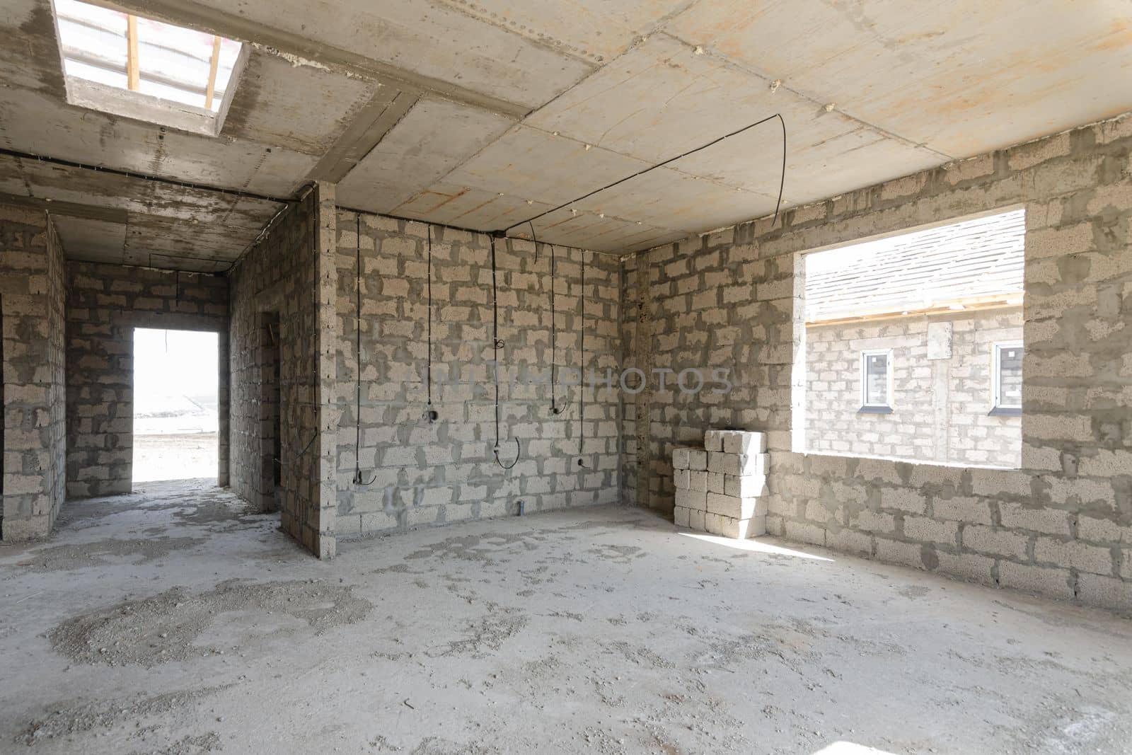 Construction of an individual residential building, view of a spacious room with a large window opening and a corridor leading to the front door by Madhourse