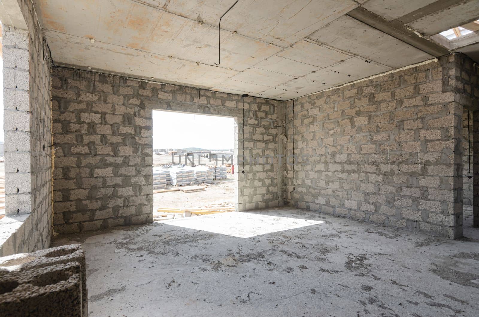 Construction of an individual residential building, view of a spacious room with a huge window opening a