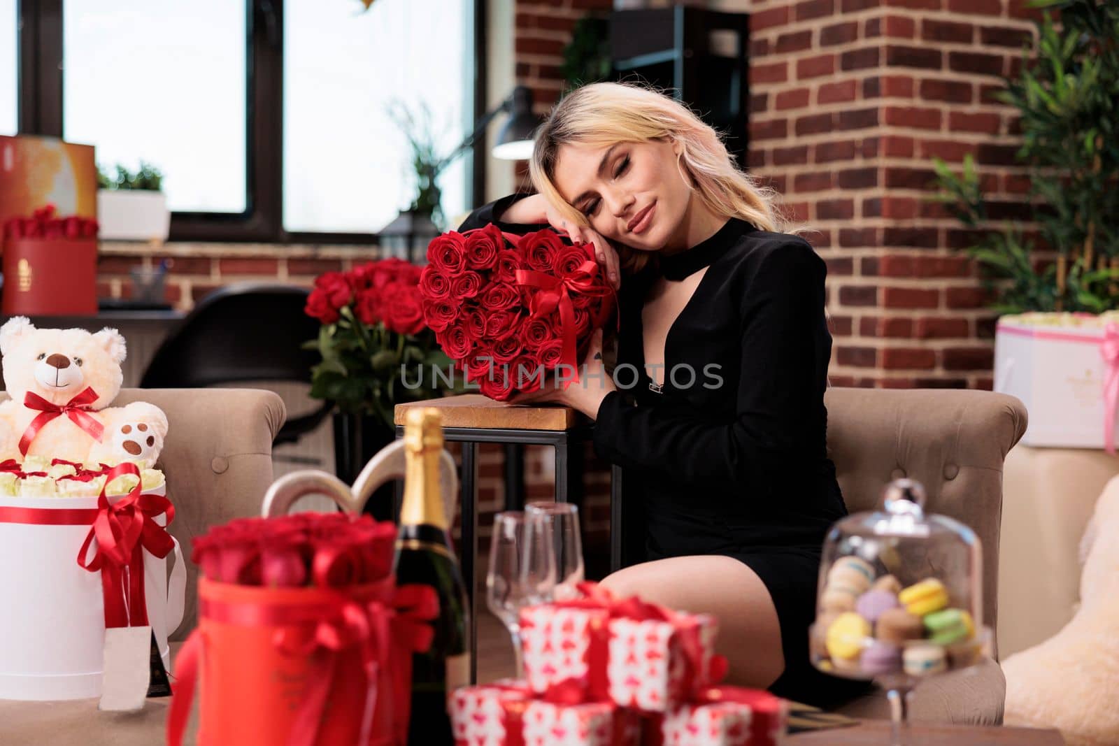 Attractive blonde woman posing with valentines day red roses by DCStudio