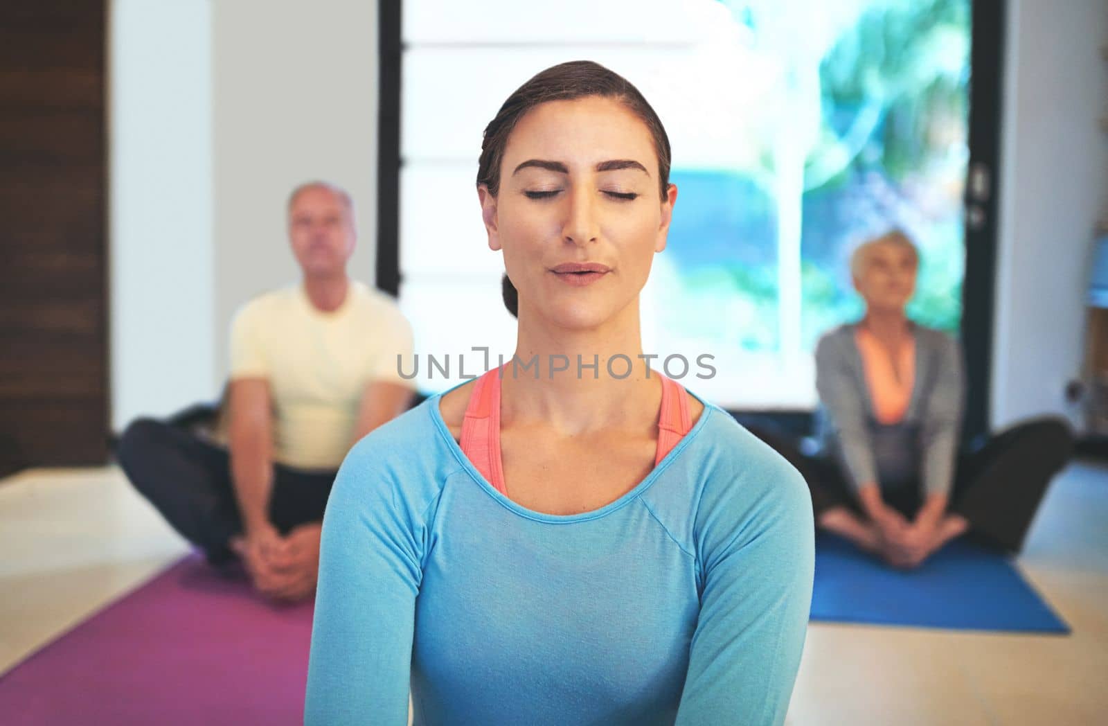 Inhale deeply, exhale slowly. a yoga instructor guiding a senior couple in a yoga class