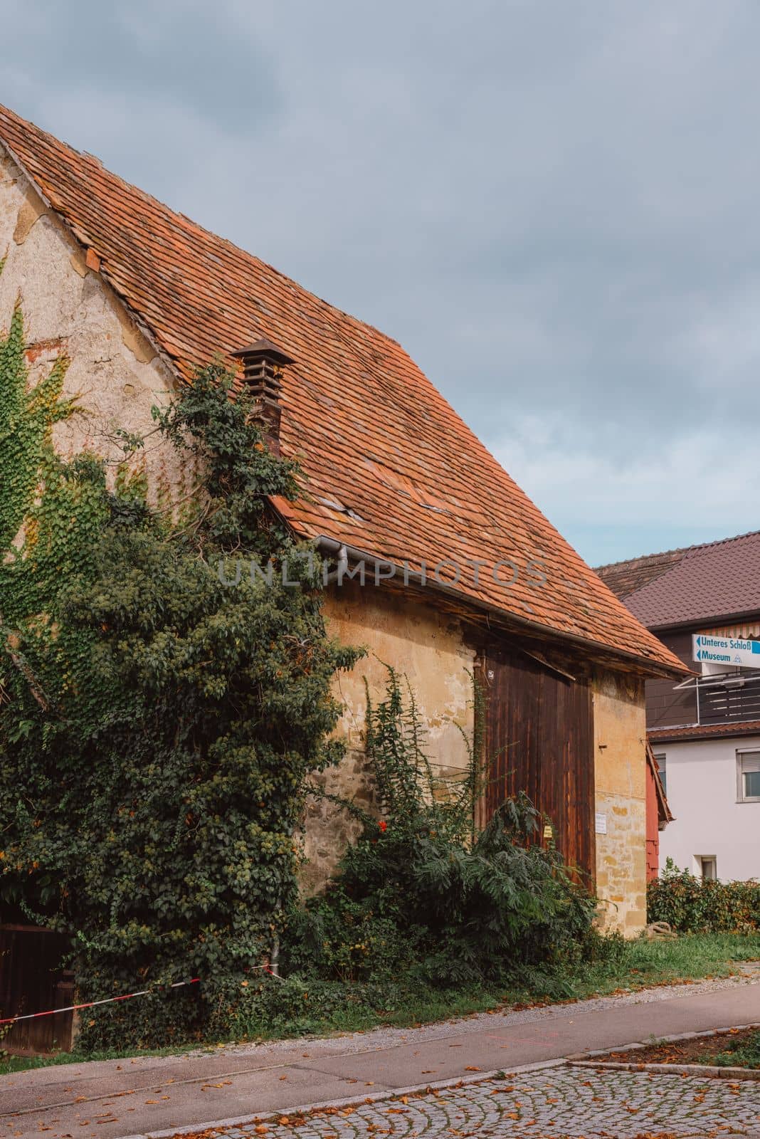 Traditional Small House With Beautiful Outdoor Decor Facade In Germany. German Old Brick Building House Ancient European City German Architect by Andrii_Ko