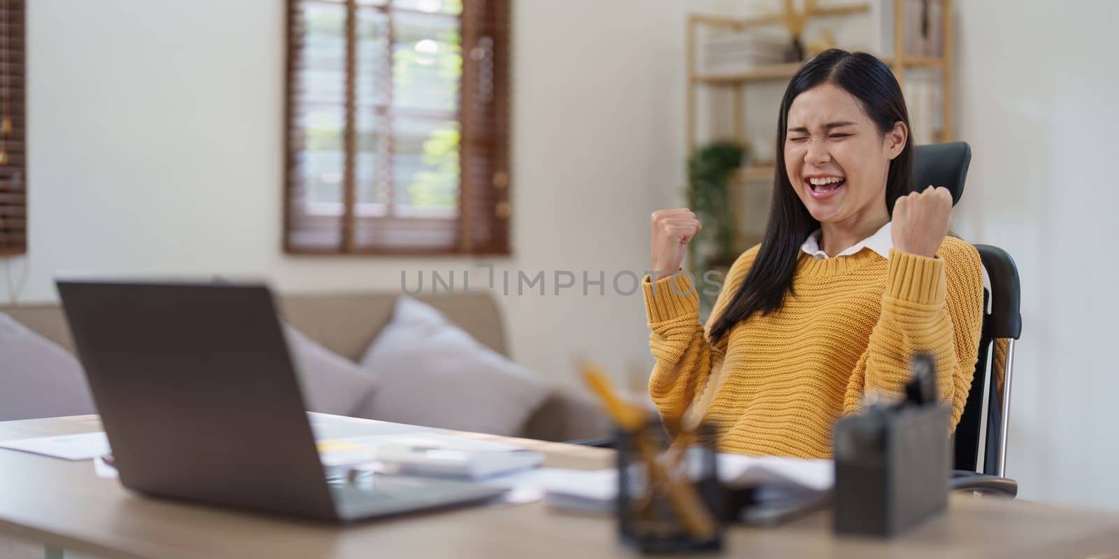 Young happy woman using laptop and celebrating victory and success, have good news, job celebrating achievement