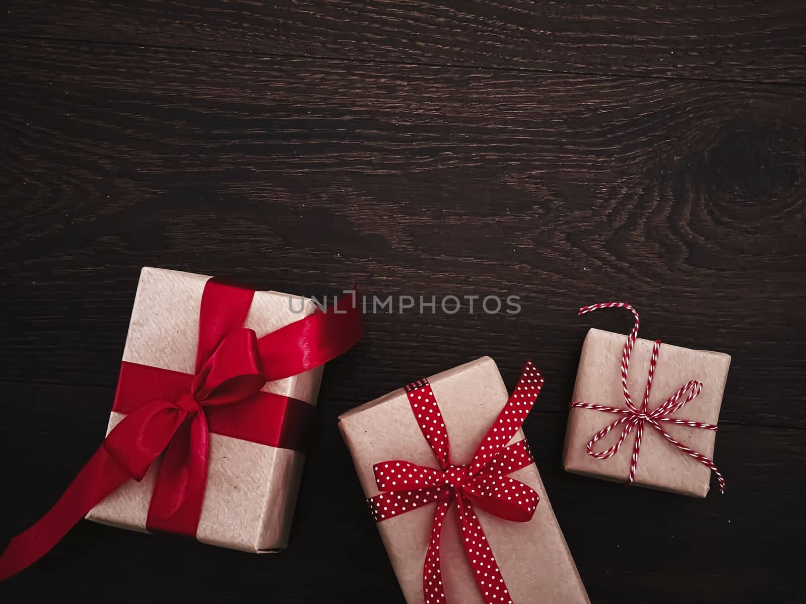 Christmas gifts and traditional holiday presents, classic xmas gift boxes on wooden background, present wrapped in craft paper with red ribbon, vintage rustic countryside style for seasonal holidays by Anneleven