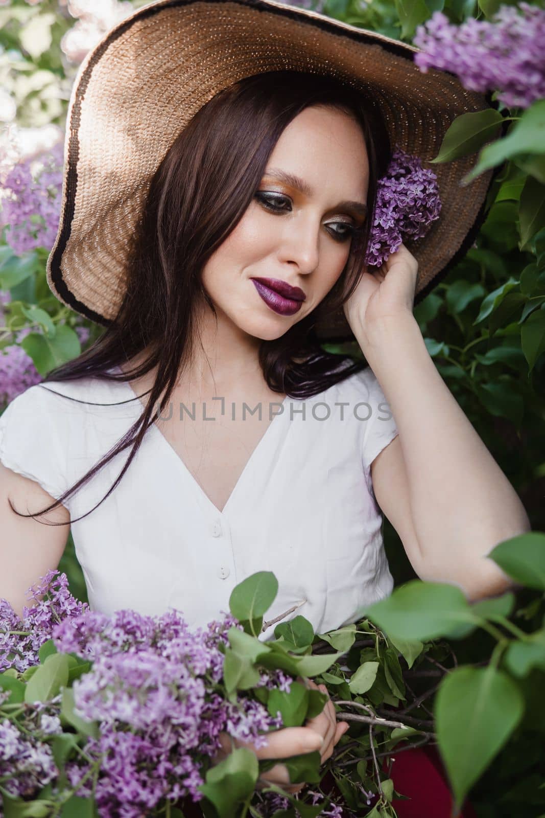 A fashionable girl with dark hair, a spring portrait in lilac tones in summer. Bright professional makeup