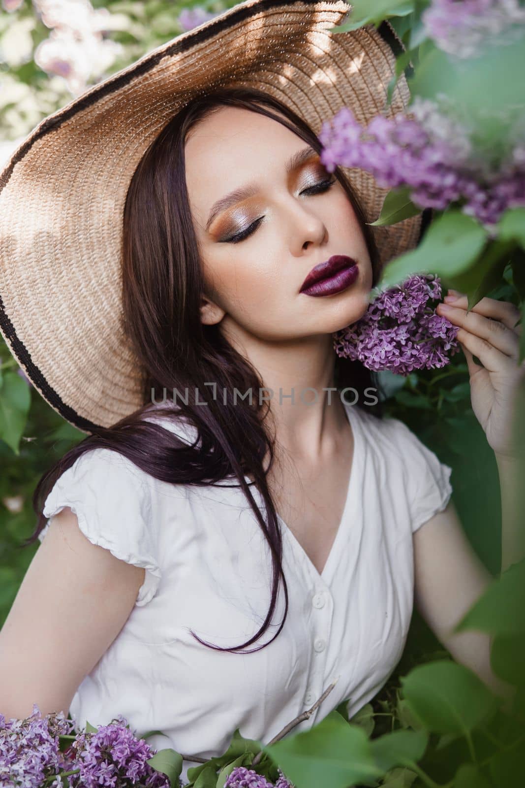 A fashionable girl with dark hair, a spring portrait in lilac tones in summer. Bright professional makeup