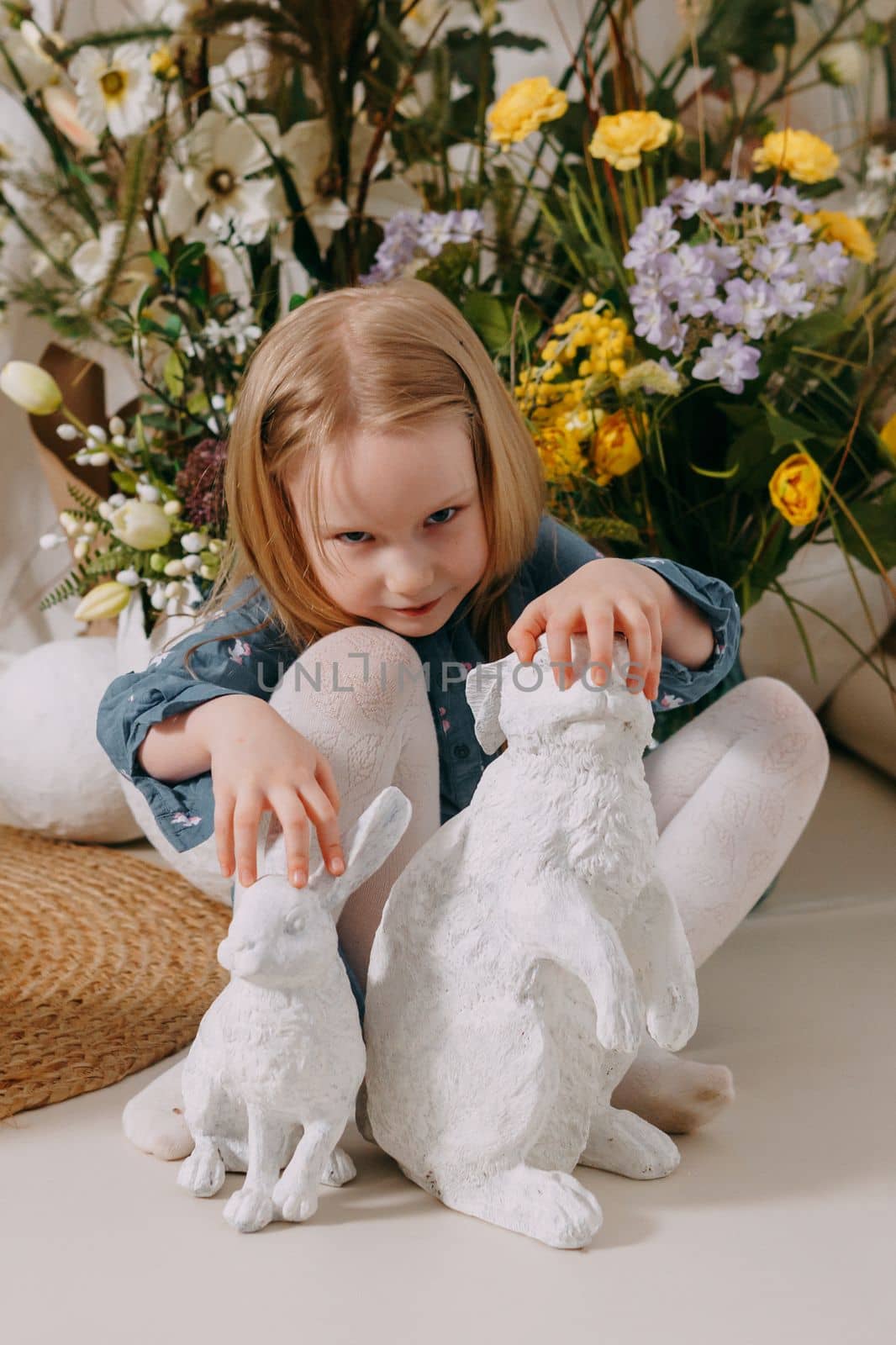 Two girls in a beautiful Easter photo zone with flowers, eggs, chickens and Easter bunnies. Happy Easter holiday. by Annu1tochka