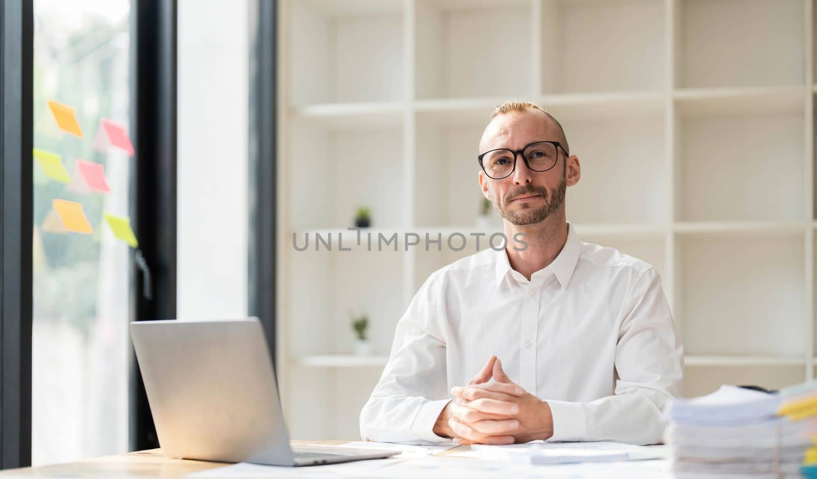 Businessman using laptop computer in office. Happy middle aged man, entrepreneur, small business owner working online...