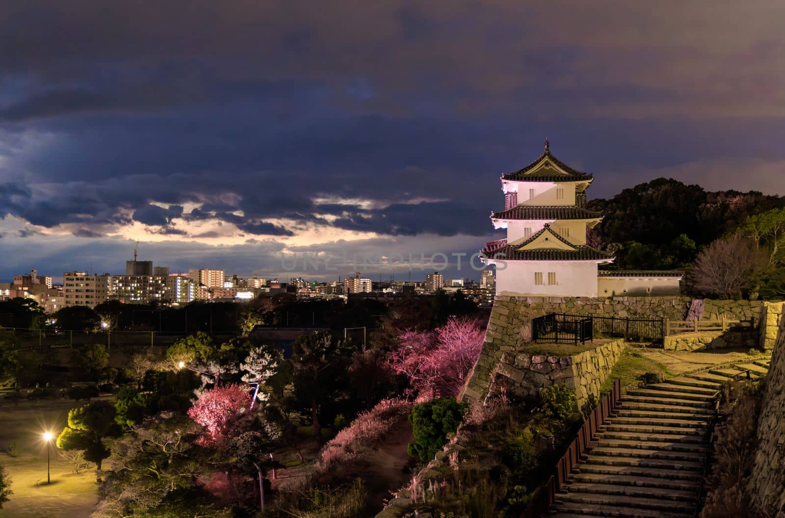 Ancient watchtower over castle grounds lit up after sunset by Osaze