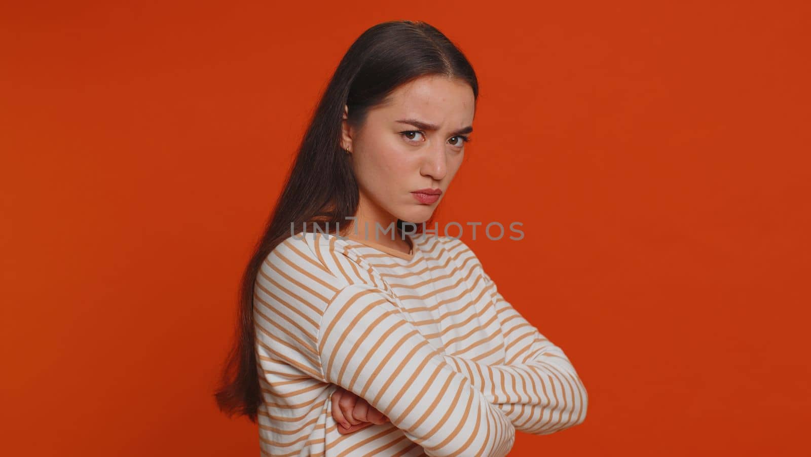Dissatisfied pretty nervous woman asking reason of failure, expressing disbelief irritation, feeling bored, disappointed in result, bad news. Young adult girl isolated alone on red studio background