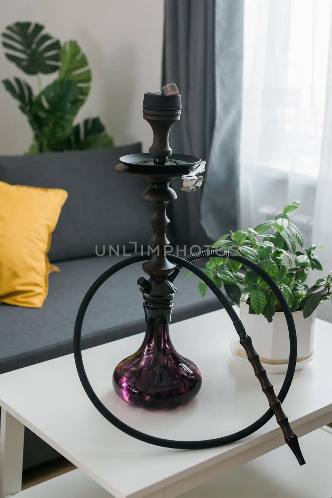 Shisha hookah bowl with red hot coals and craft tobacco. Sparks from breathe. Modern hookah with coconut charcoal for relax and smoke. Beautiful sparks in long exposure on dark lounge background.