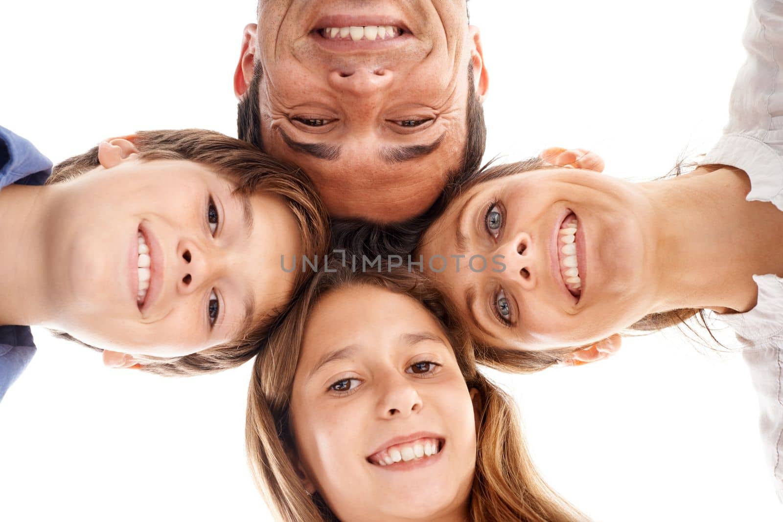 Family huddle. Low-angle shot of a happy family of four standing in a huddle. by YuriArcurs