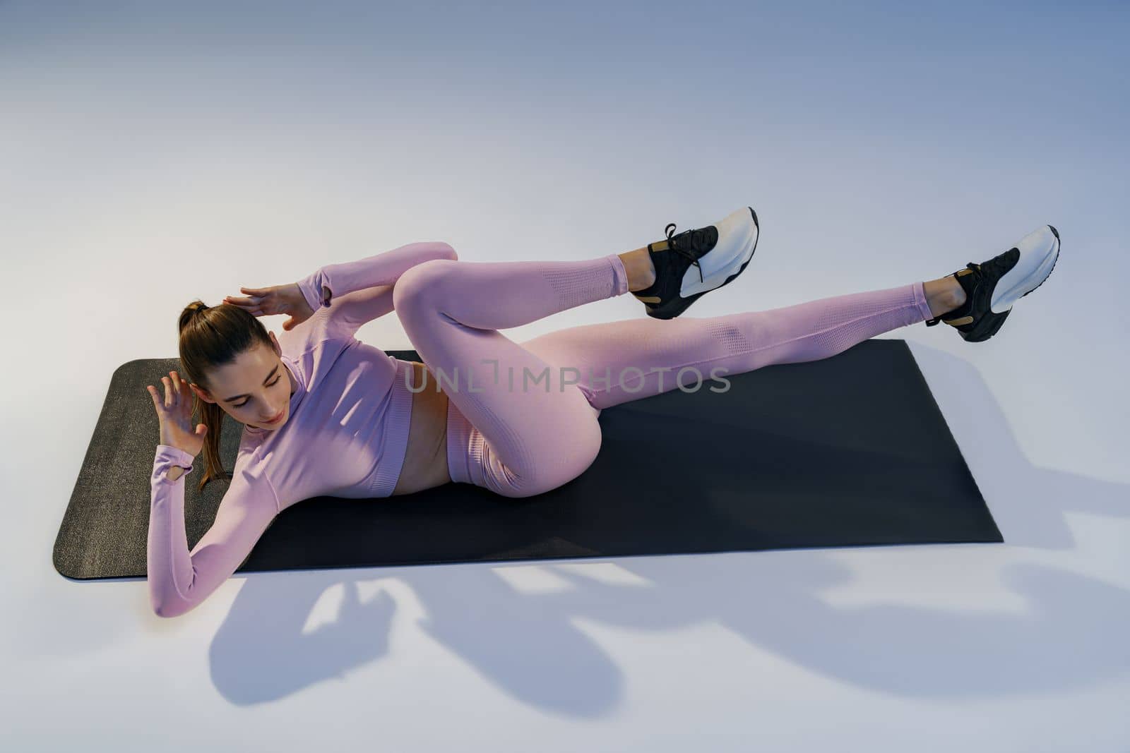 Athletic woman shaking press on studio background. Fitness, healthy lifestyle and sport concept by Yaroslav_astakhov