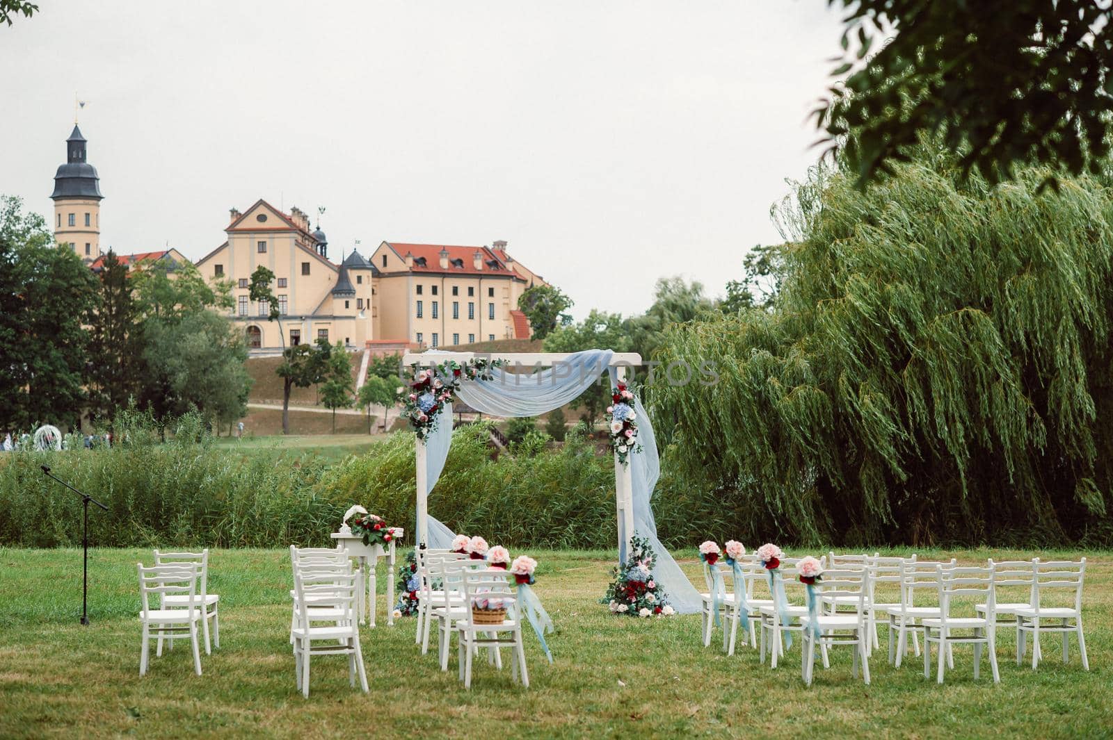 Wedding ceremony on the street on the green lawn.Decor with fresh flowers arches for the ceremony by Lobachad