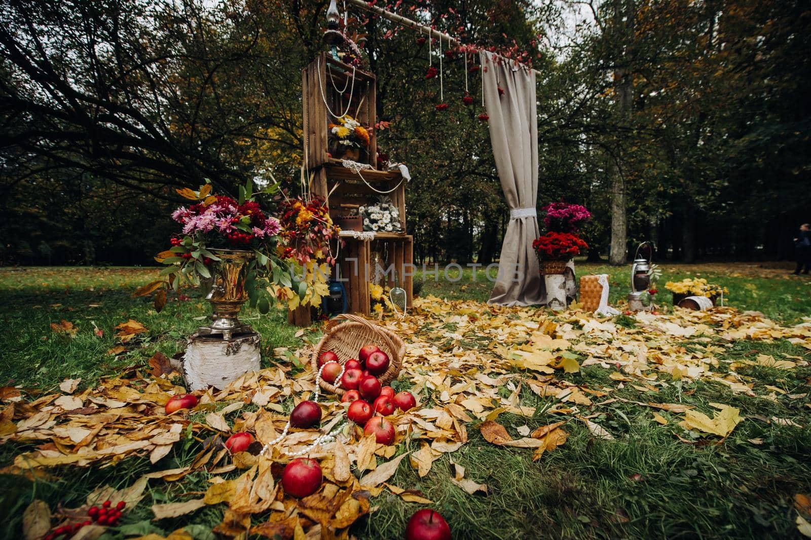 Autumn wedding ceremony on the street on the green lawn.Decor with arches of fresh flowers for the ceremony.