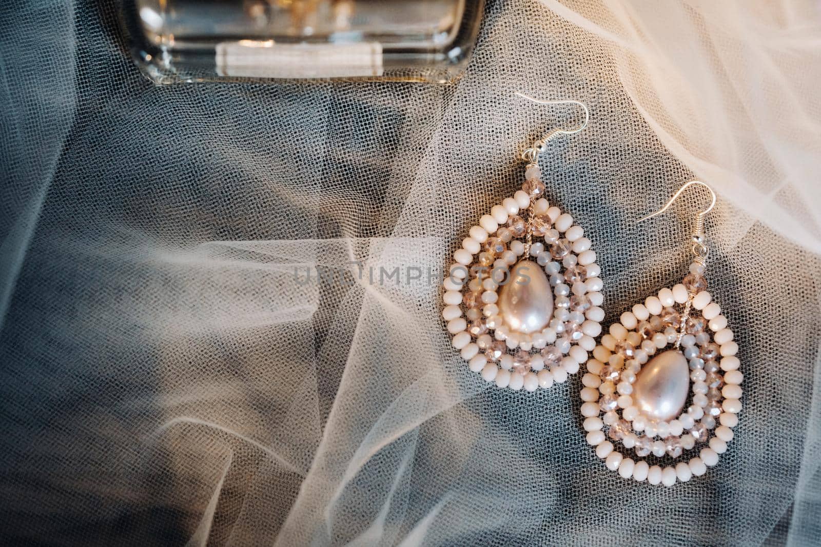 Accessories for the bride. Earrings on the veil. White wedding earrings. Space for text and ads