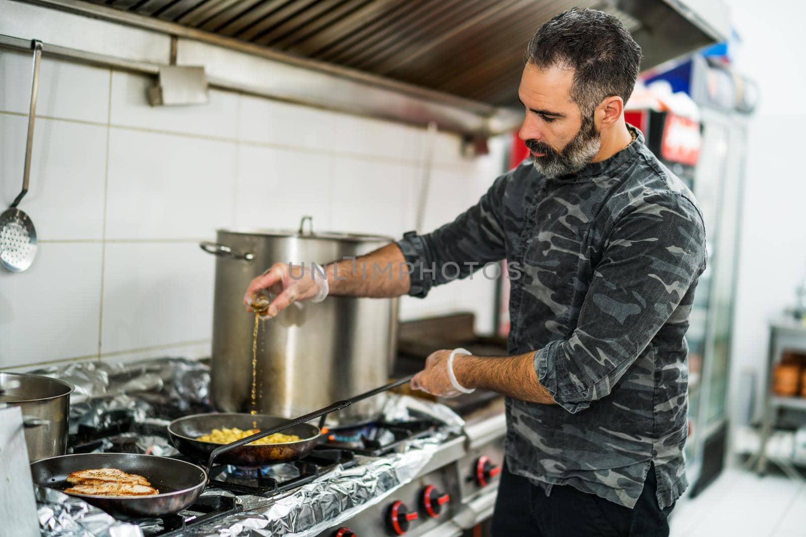 Professional cook is preparing meal in restaurant's kitchen.