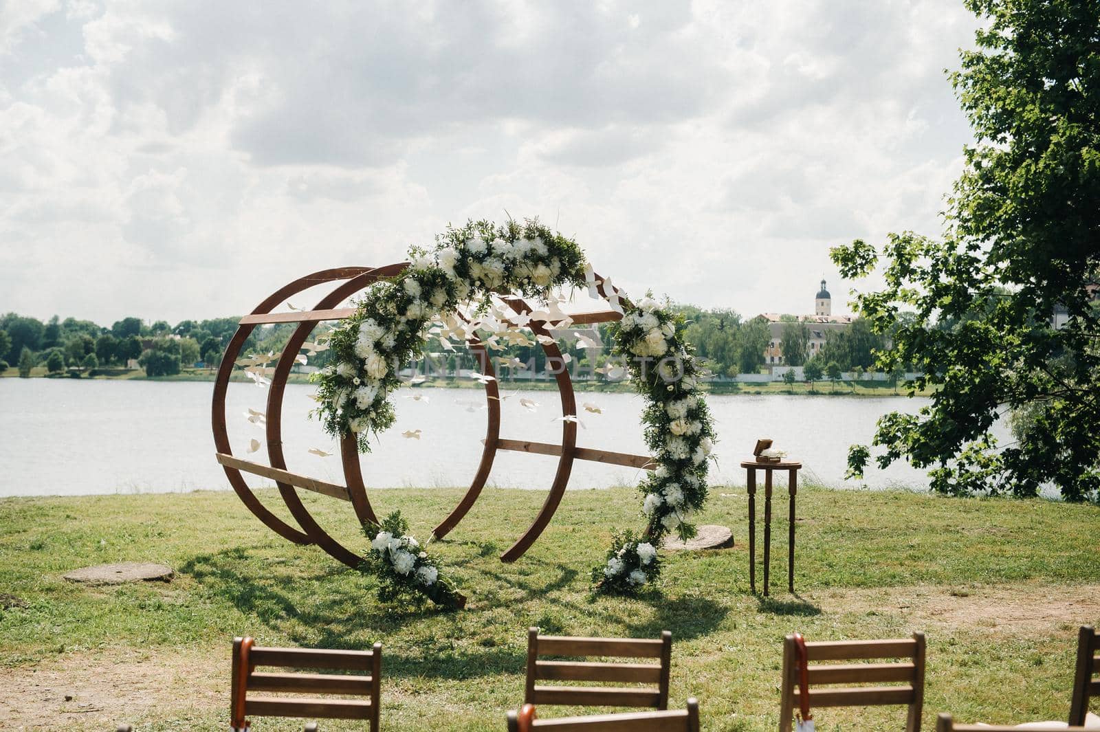 Wedding ceremony on the street on the green lawn.Decor with fresh flowers arches for the ceremony.