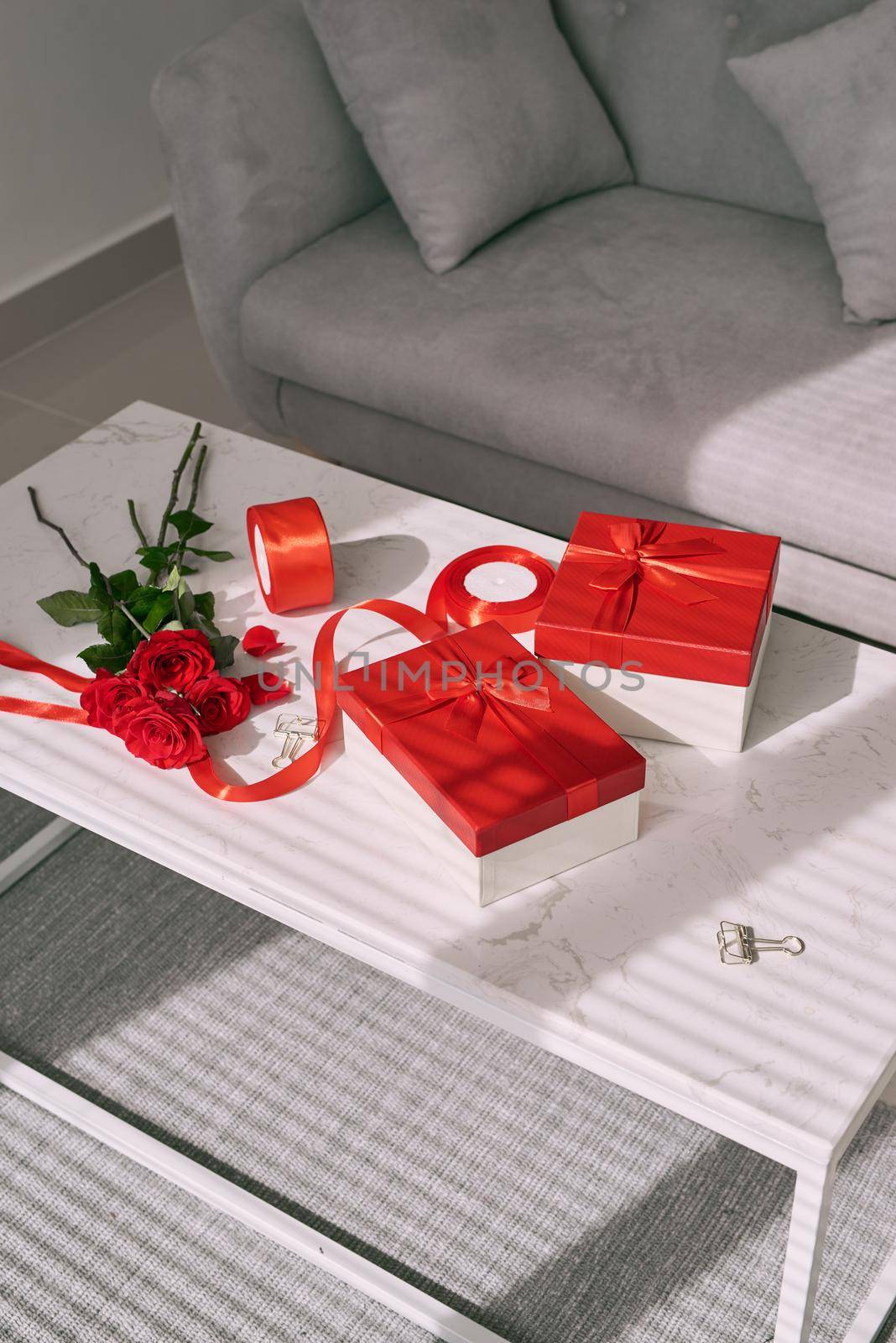 Love gift wrapping with rolls of  paper and bouquet of roses