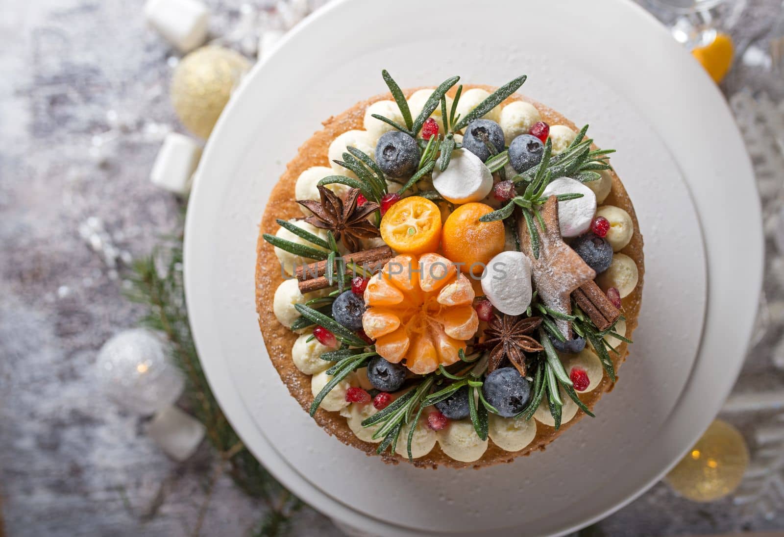 Festive Christmas cake on a rustic wooden stand and holiday decoration by aprilphoto