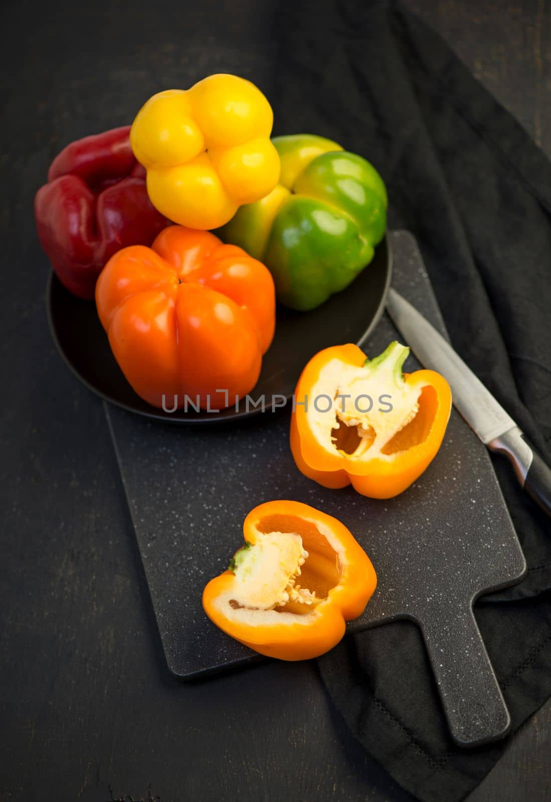 colored peppers on black background