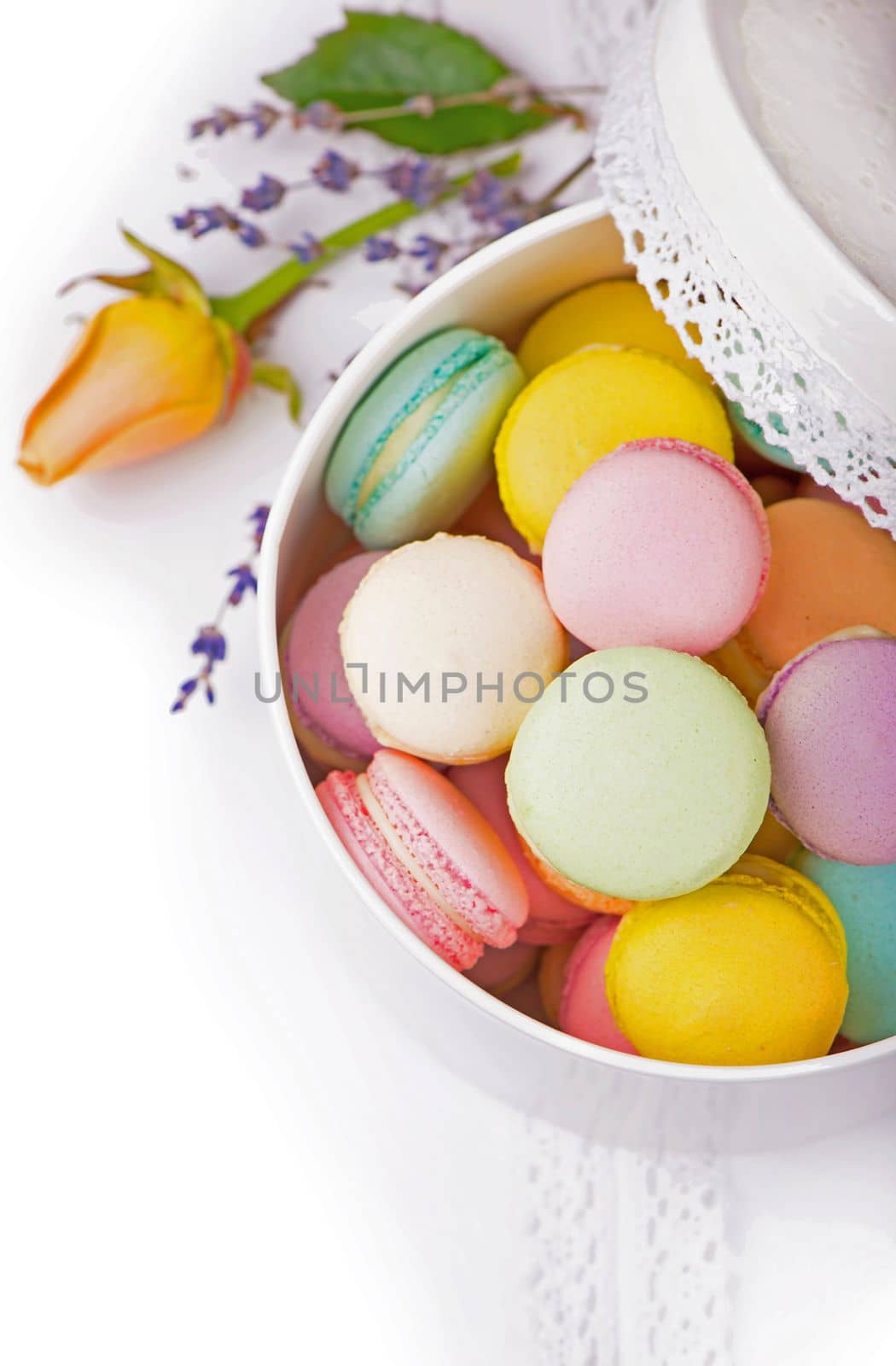 Many delicious colorful macarons in box on white background by aprilphoto