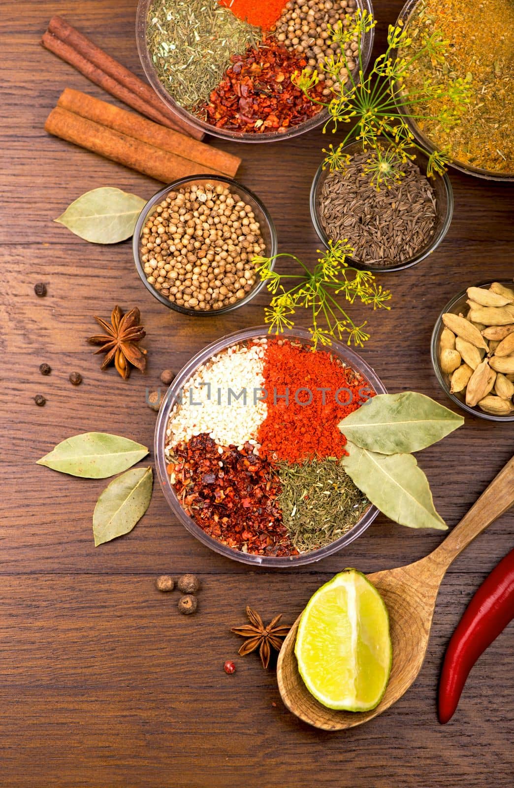 Set of spices and herbs. Indian food. Pepper, salt, paprika, basil, turmeric. On a black wooden board. View from above. Free copy space. by aprilphoto