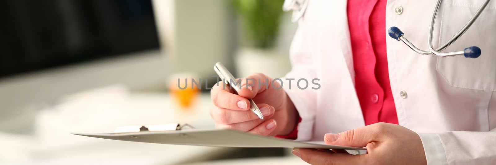 Hands of doctor hold clipboard and write down results of examination with pen. Full medical comprehensive examination of patient and health insurance