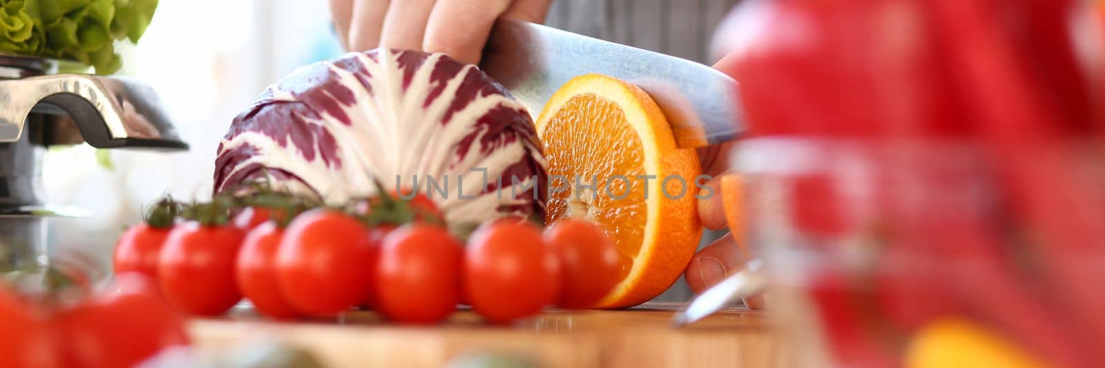 Chef man cut vegetables and fruits on cutting board closeup. Concept of healthy food and vegetarianism