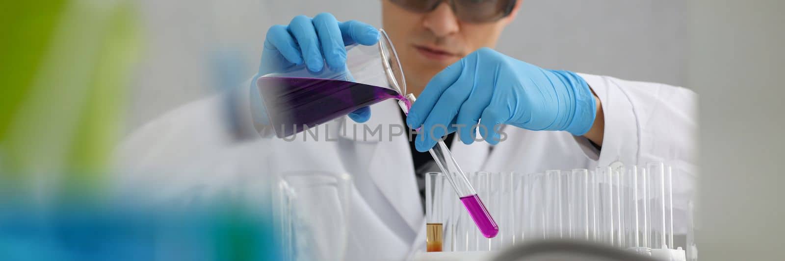 Scientist in protective gloves holding test tube of purple liquid. Laboratory research of poisonous liquids concept
