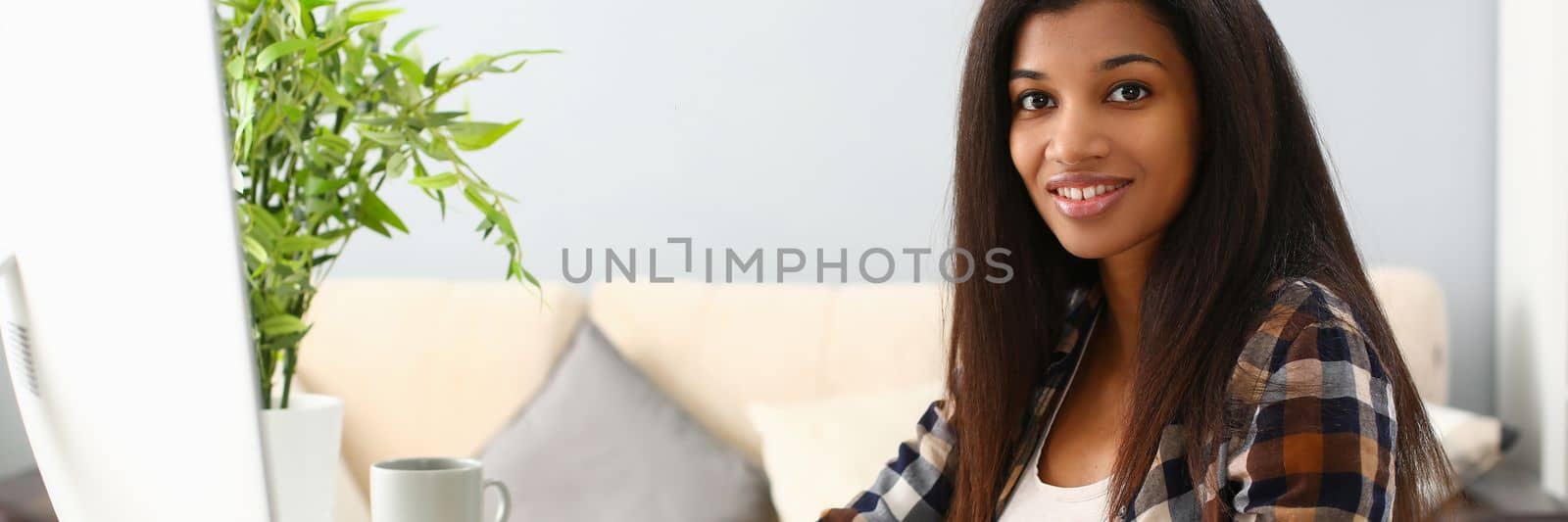 Positive afro business woman smiling at workplace at home. Remote work freelance and telework for students