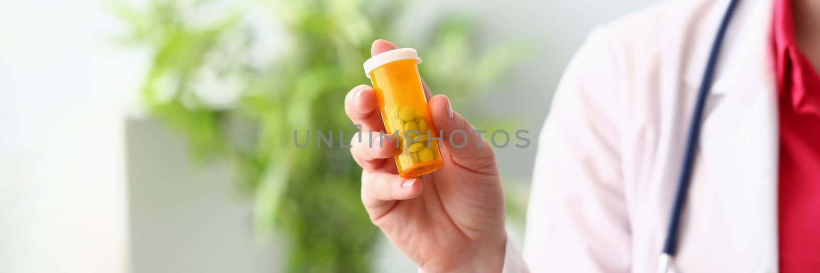 Female doctor hand holding medical pills or pill jar mockup by kuprevich