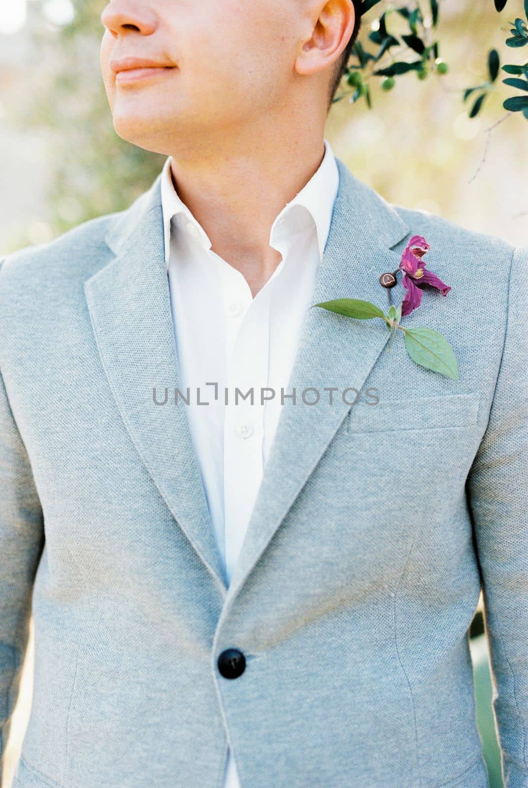 Groom in a gray jacket with a boutonniere. Cropped. High quality photo