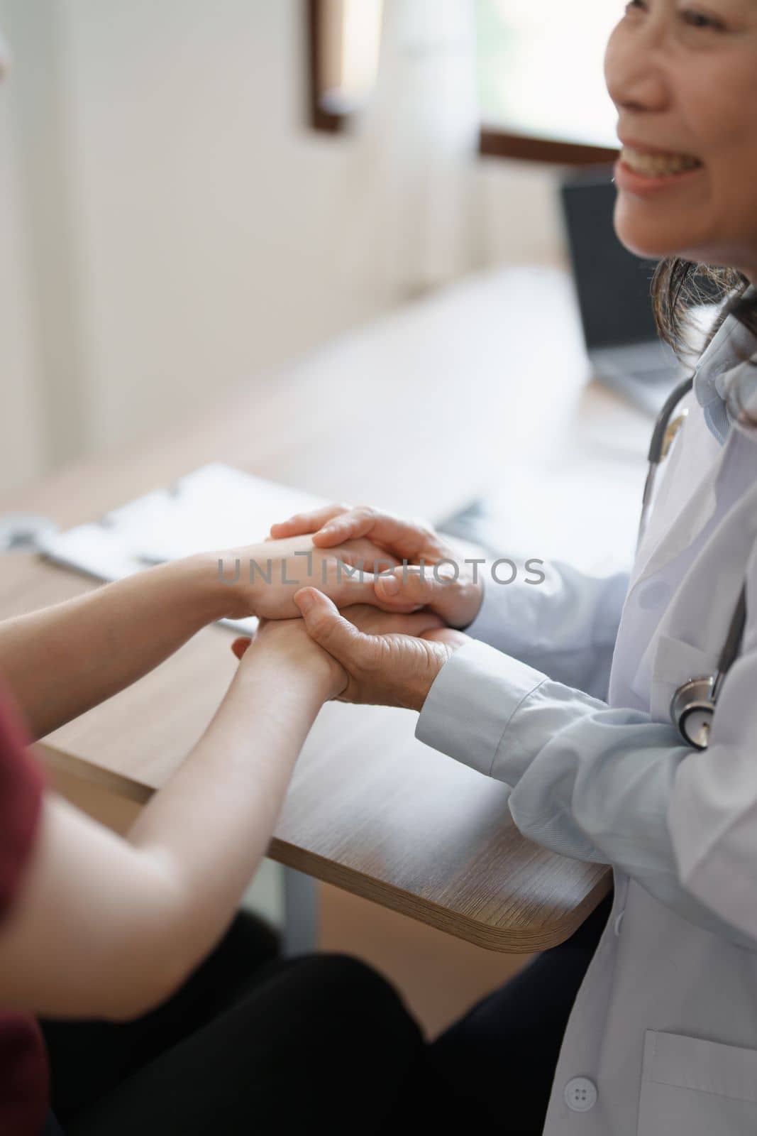 Portrait of a female doctor holding a patient's hand to encourage the fight against disease