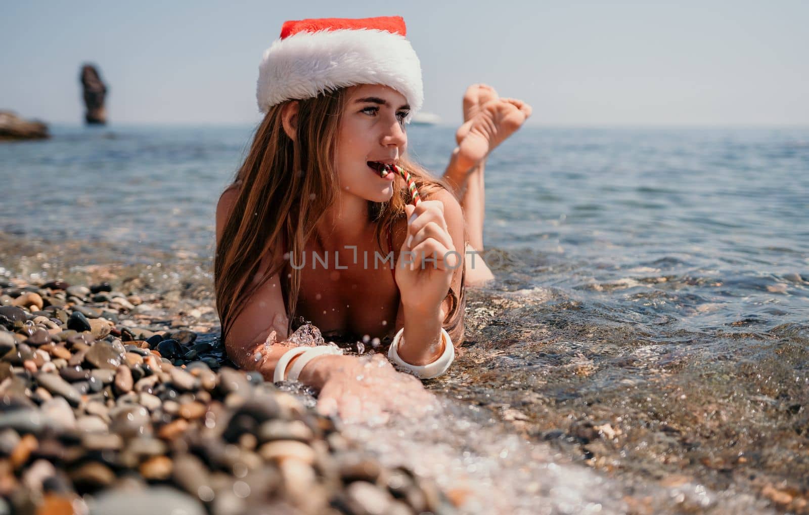 Woman travel sea. Happy tourist enjoy taking picture on the beach for memories. Woman traveler in Santa hat looks at camera on the sea bay, sharing travel adventure journey by panophotograph
