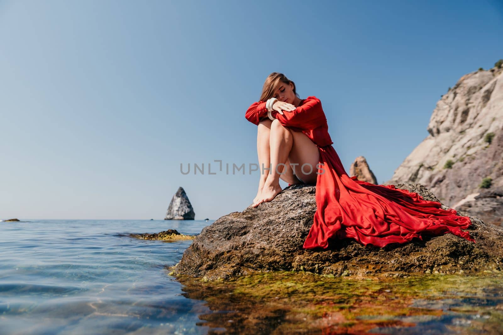 Woman travel sea. Happy tourist taking picture outdoors for memories. Woman traveler looks at the edge of the cliff on the sea bay of mountains, sharing travel adventure journey.