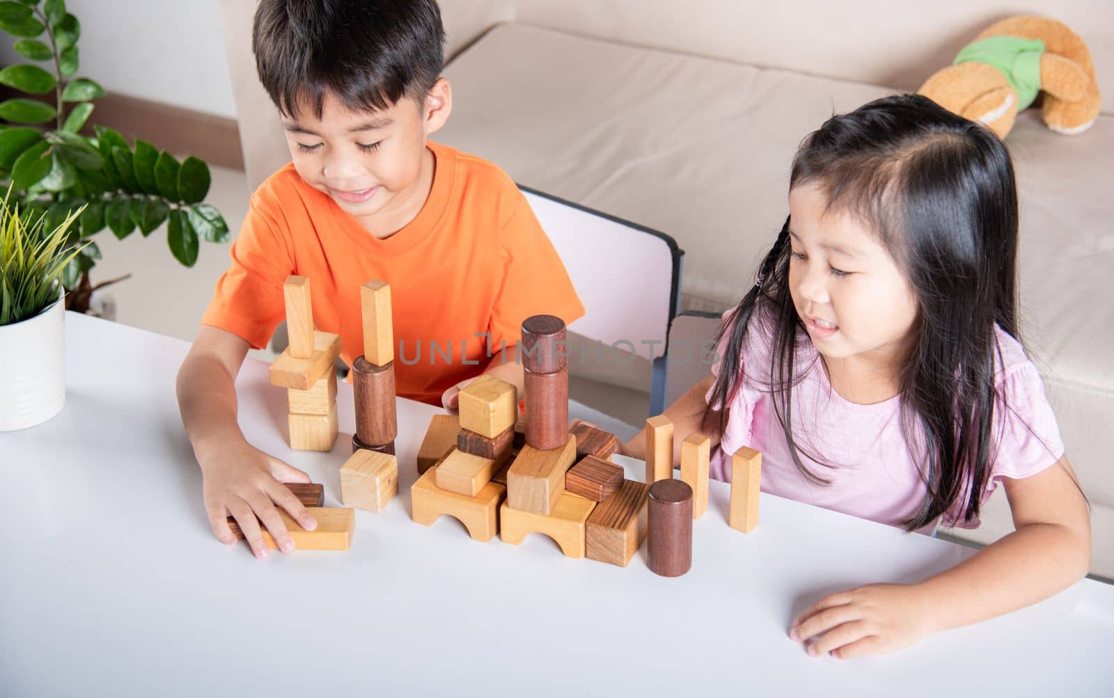 Children boy and girl playing with constructor wooden block building, Happy little kids play wood block stacking board game at home, activities learning creative, toys for preschool and kindergarten