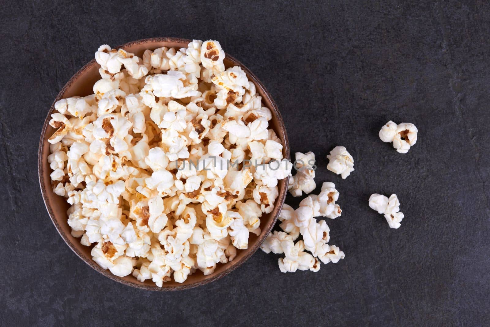 Popcorn in bowl food on black stone background