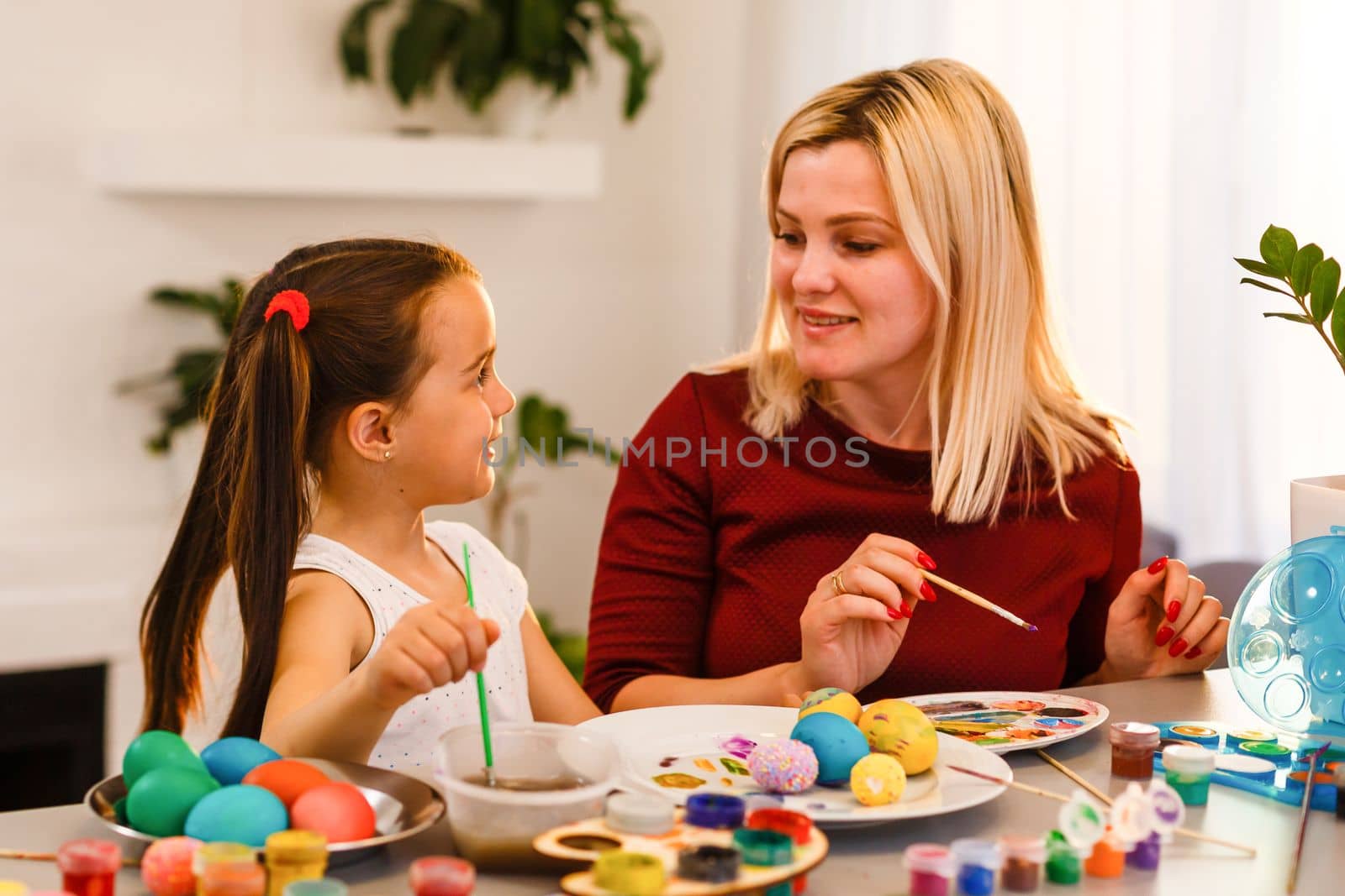 Easter Family traditions. family paint eggs at kitchen table.