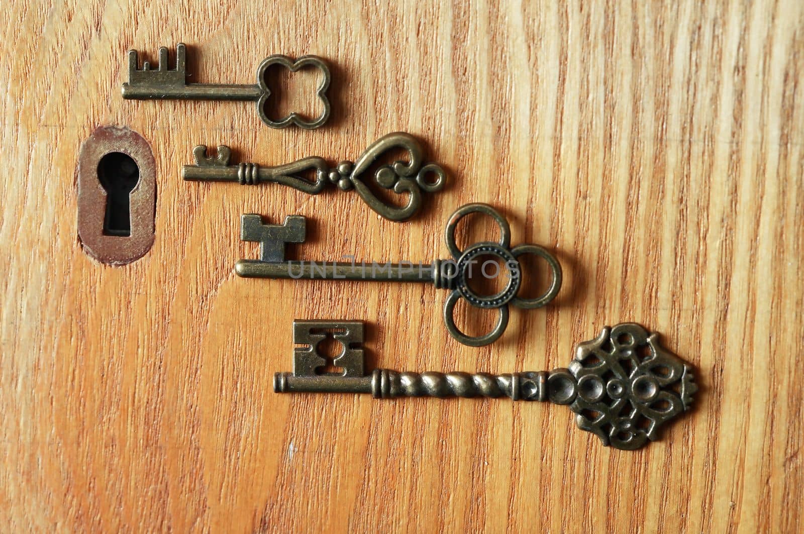 Set of various old keys closeup near keyhole