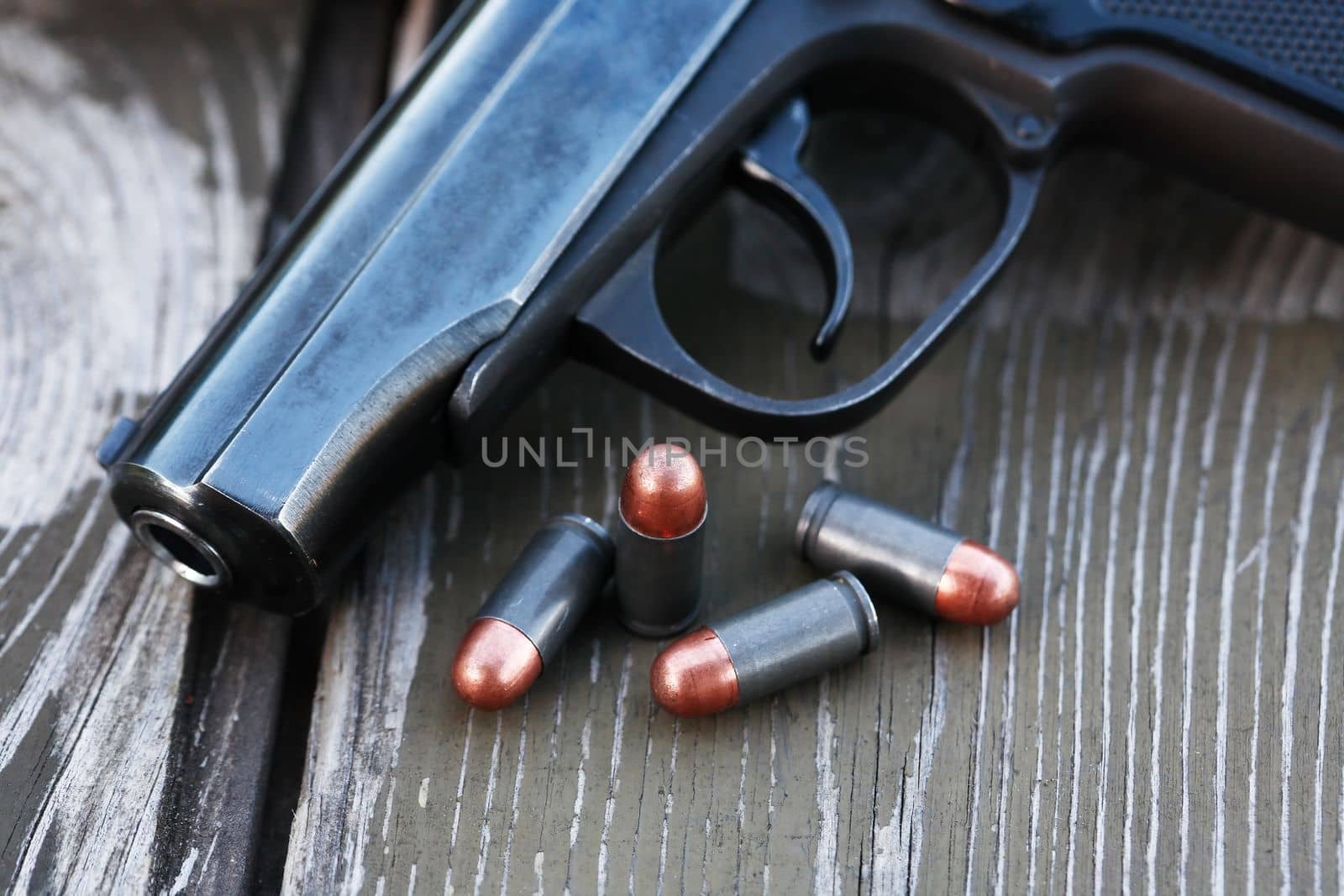 Handgun cartridges closeup on old wooden background near pistol