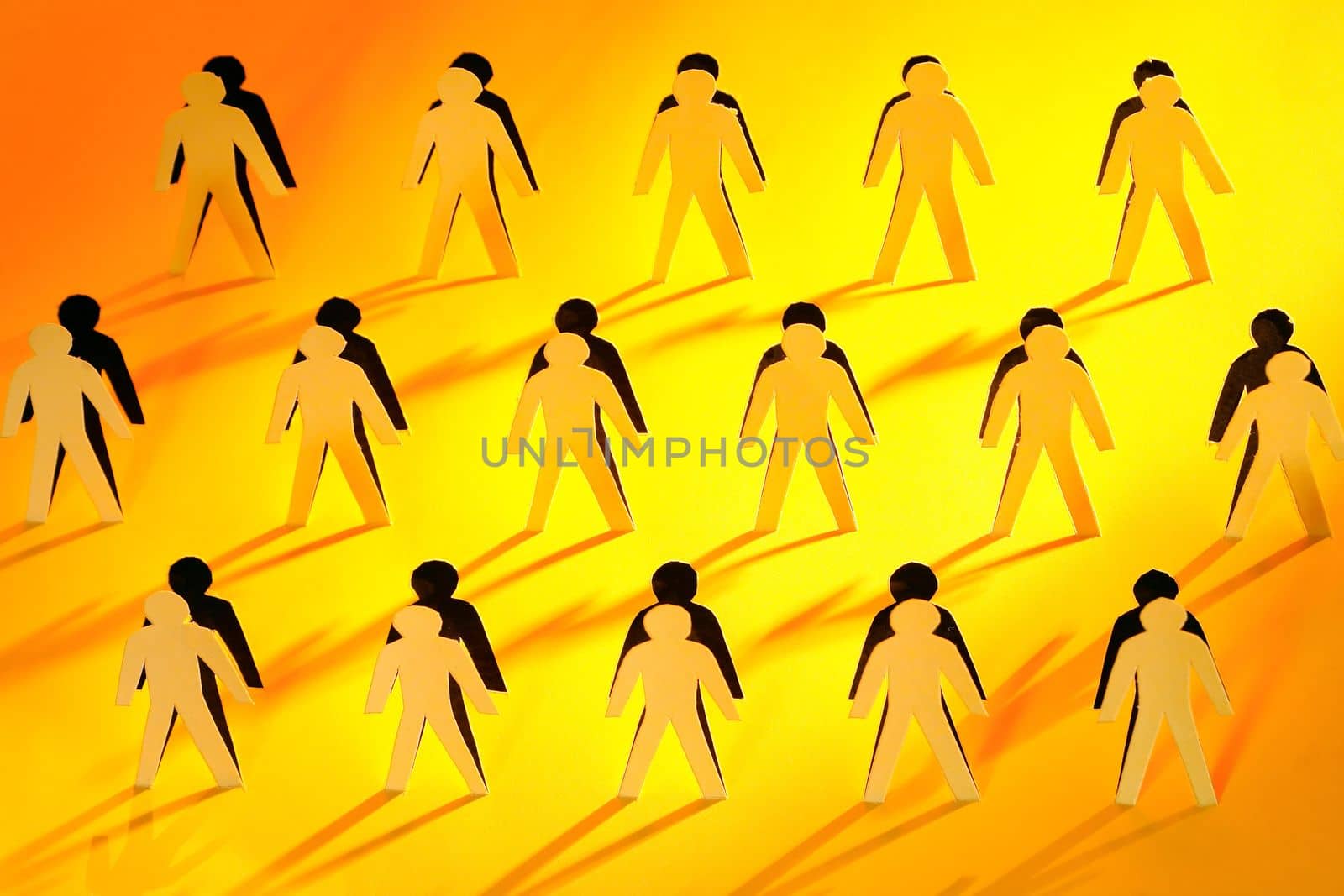 Lot of men figures cutting from yellow paper with long shadow