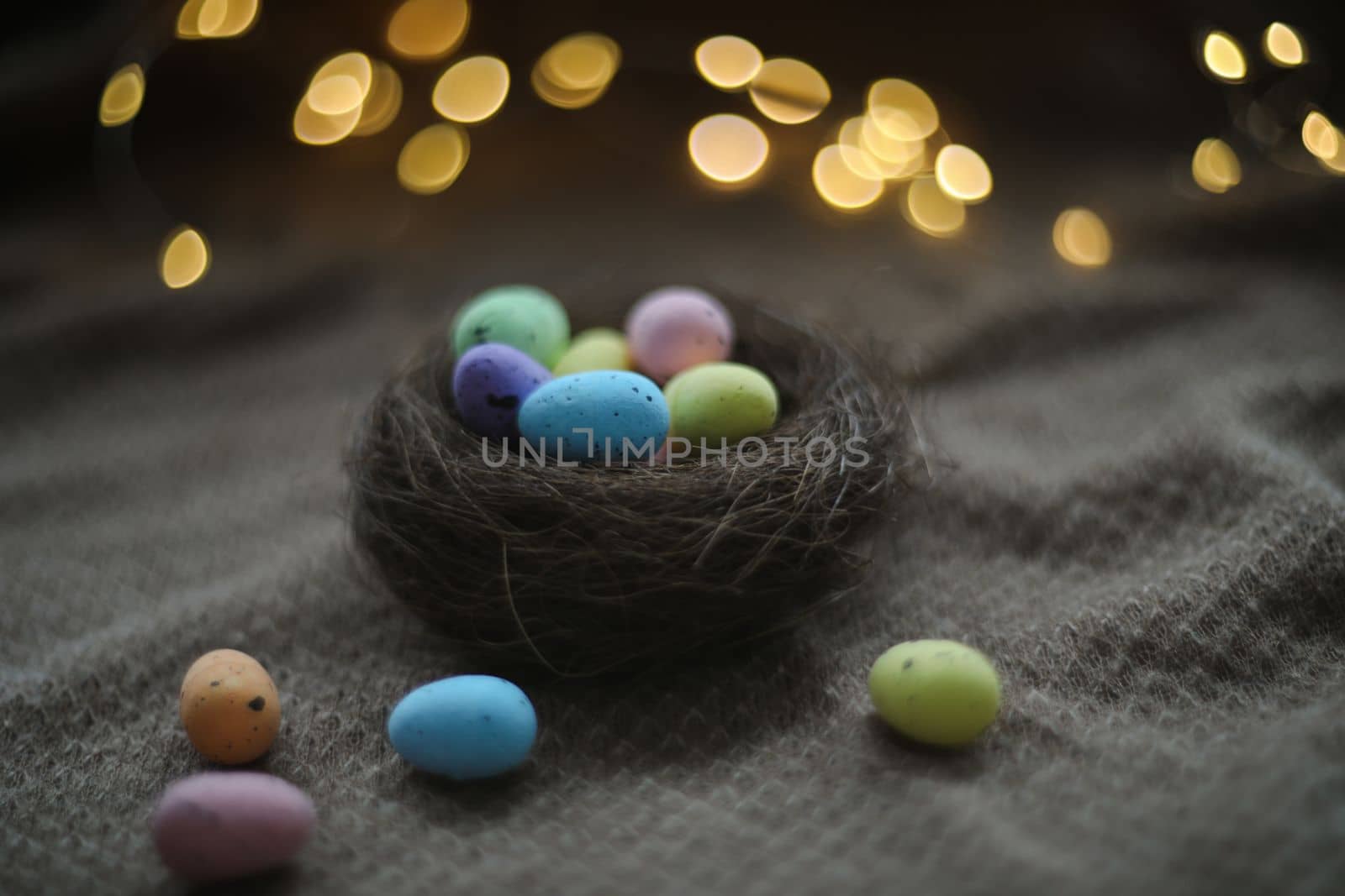 Happy Easter card. Colorful easter eggs in nest on rustic festive background with copy space, selective focus image