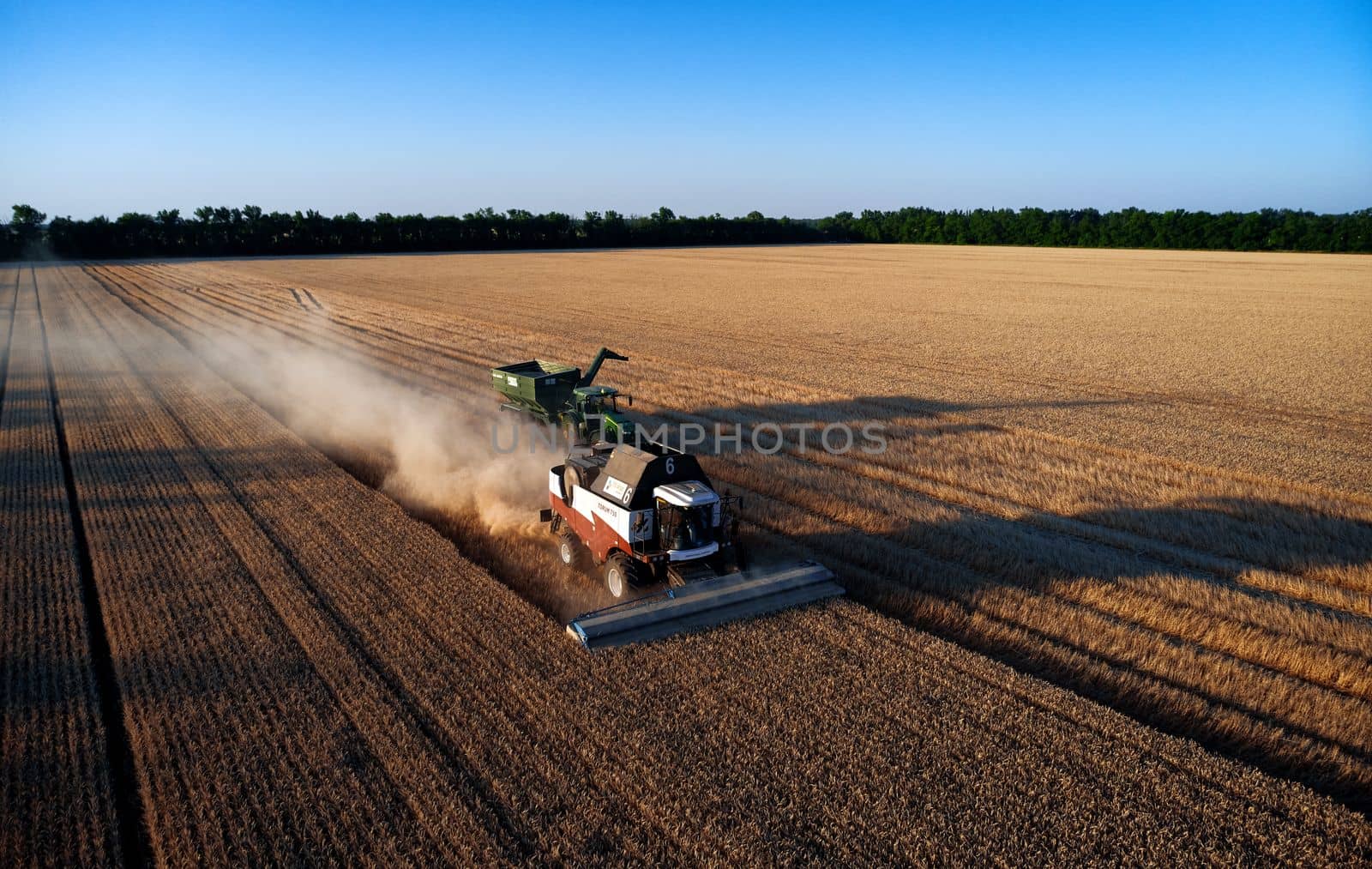 Harvester works in the field. Combine Harvesting Wheat. Field field of cereals during harvesting. Modern equipment works. 07.07.22, Rostov region, Russia.