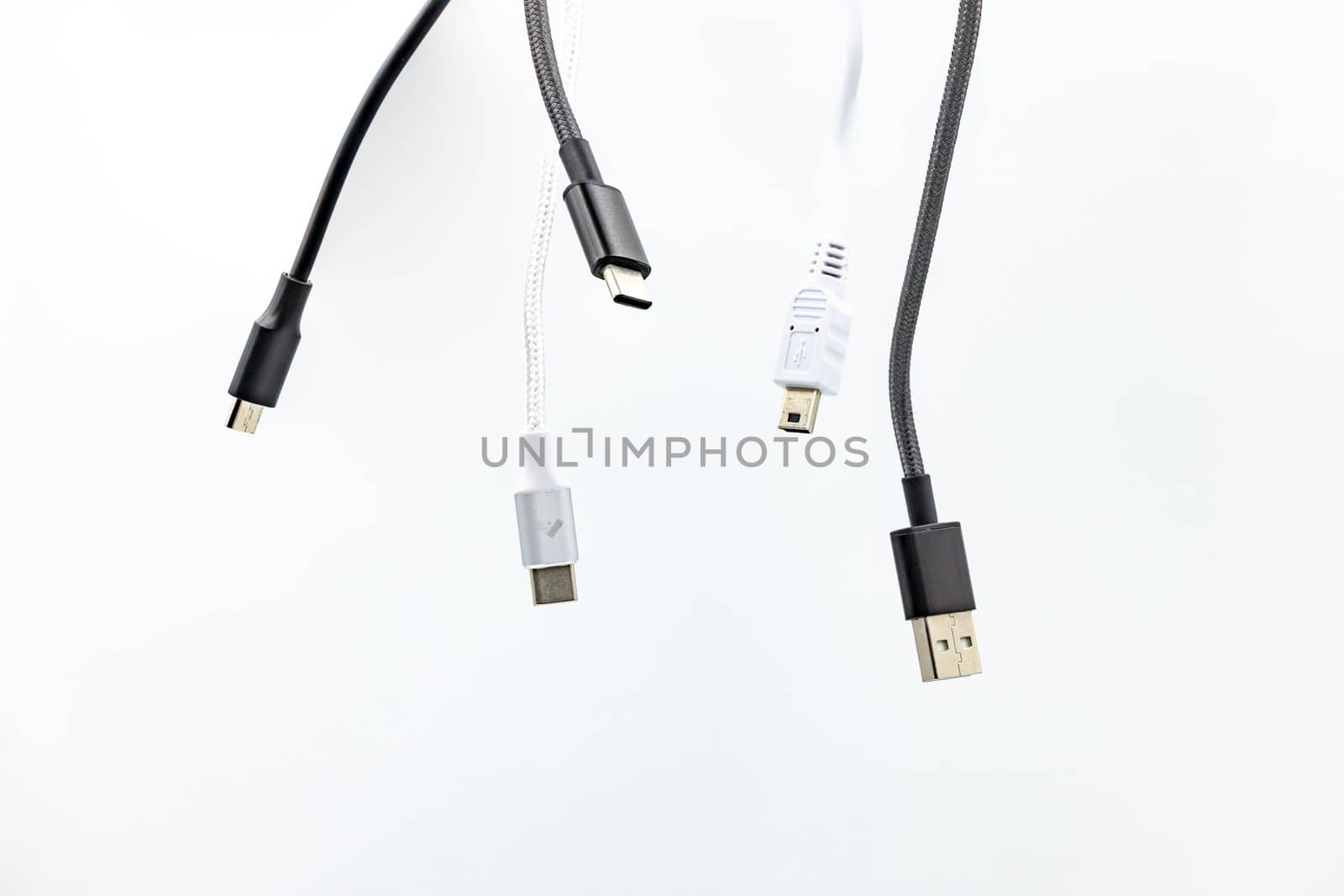 Jumble with many cables, USB plugs and standards isolated against a white background