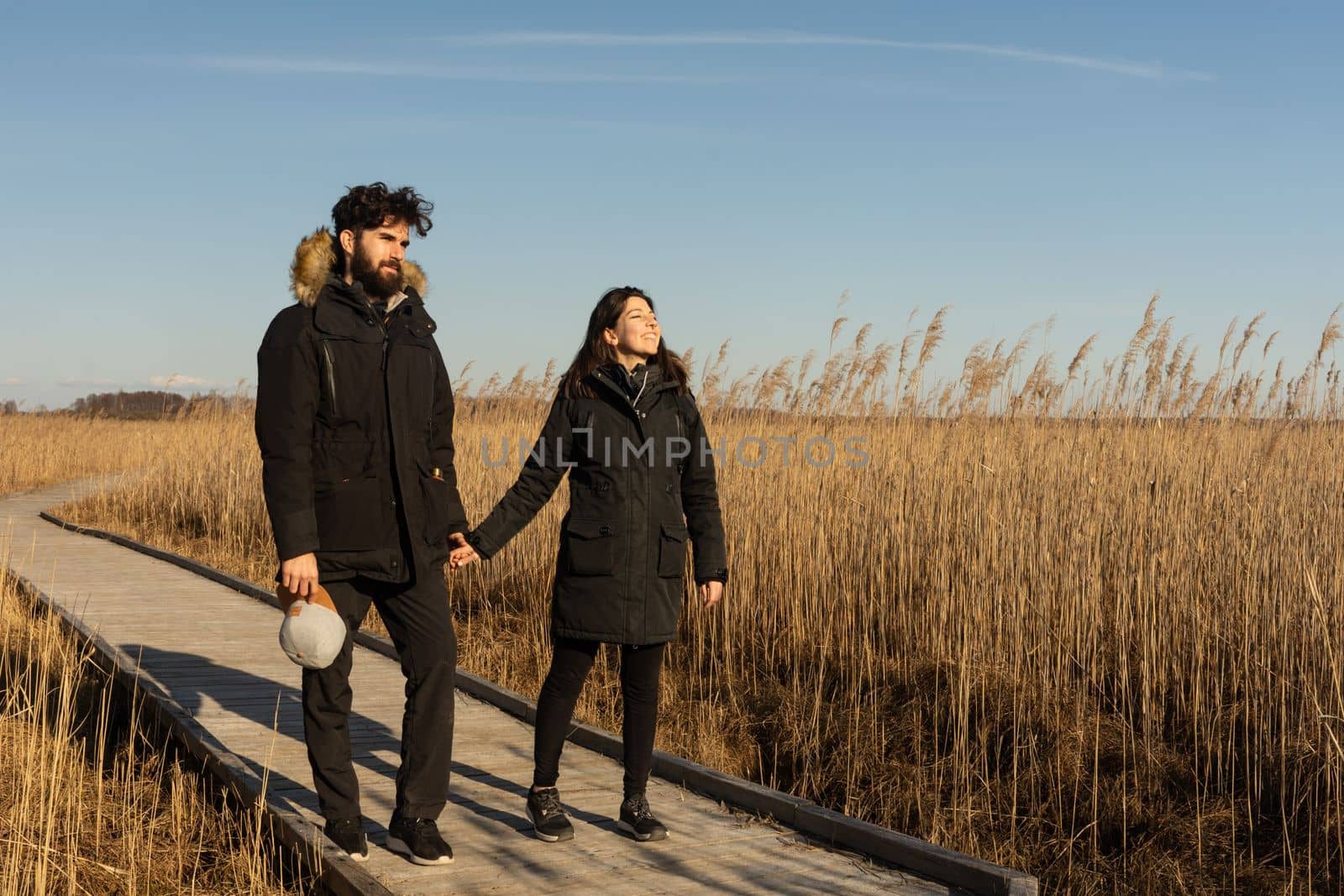 Young adult couple walking through a path in the nature in a Polish natural park. High quality photo