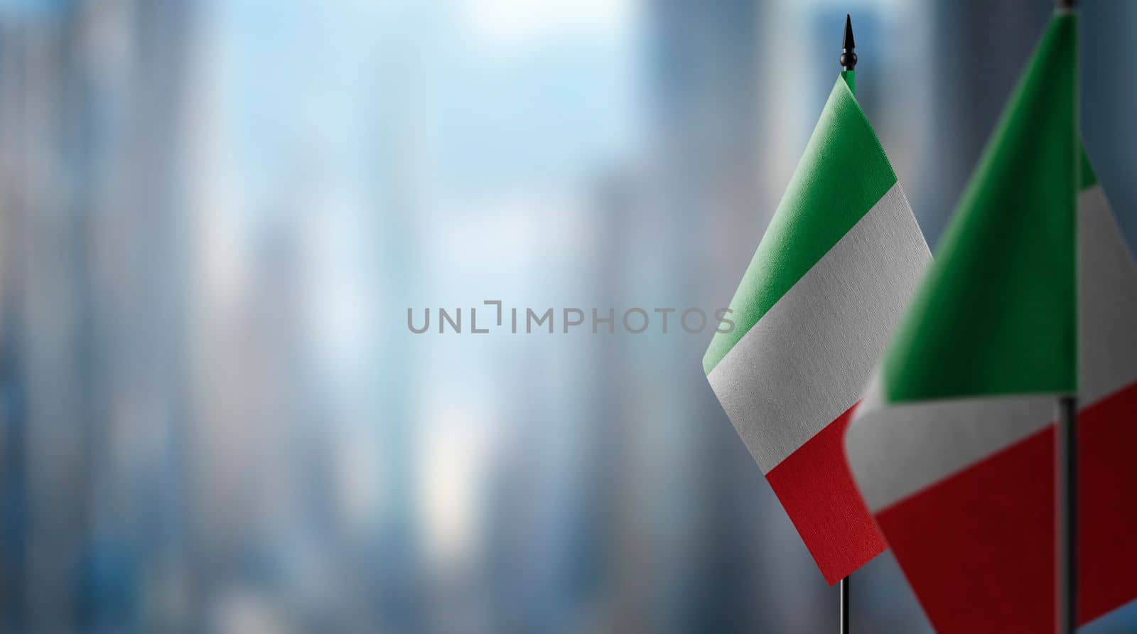 Small flags of the Italy on an abstract blurry background by butenkow